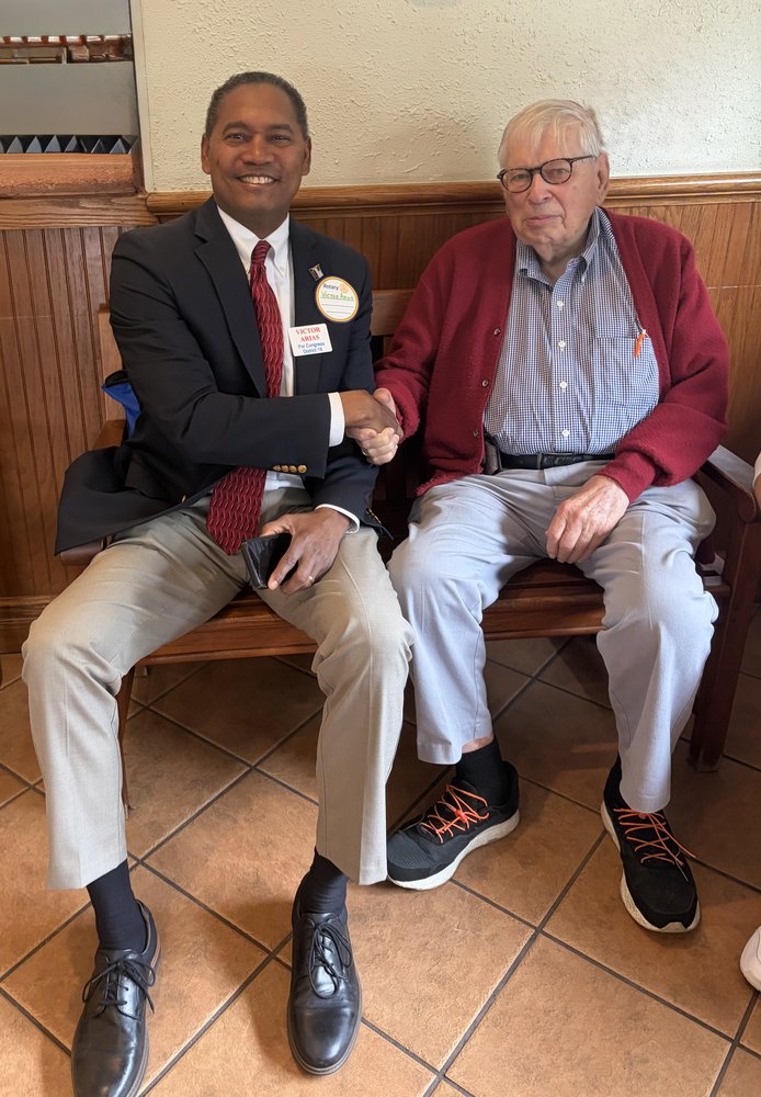 Victor Arias shaking hands with a senior community member at a Southwest Florida service organization meeting